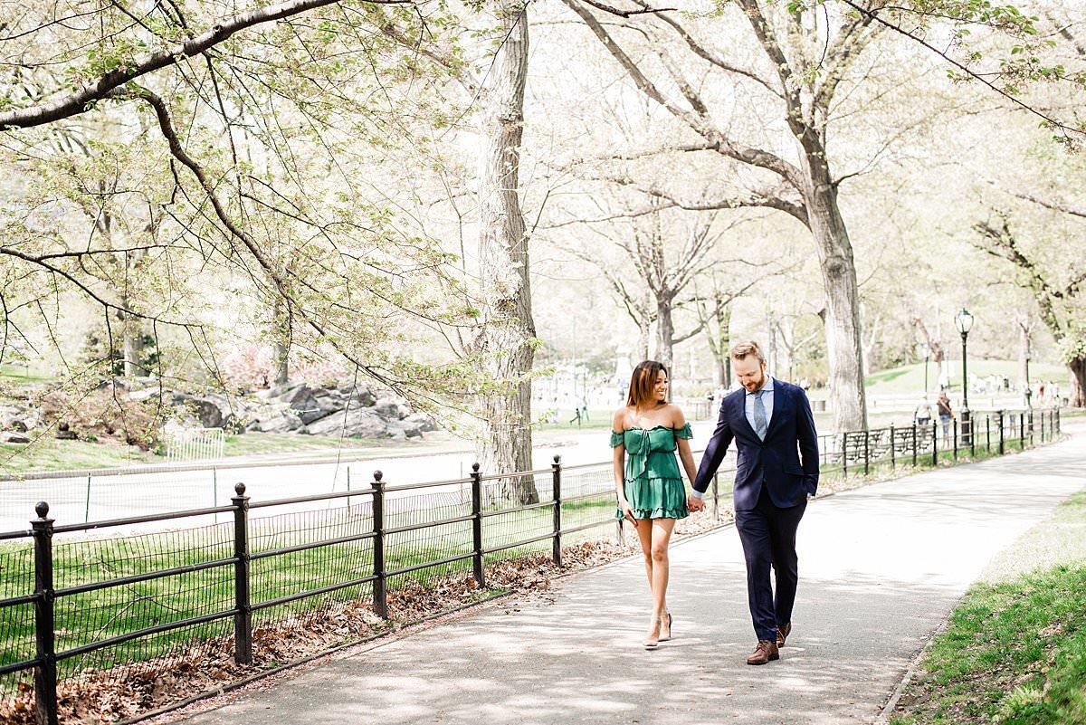 Couple walking together along a pathway in Central Park during the fall