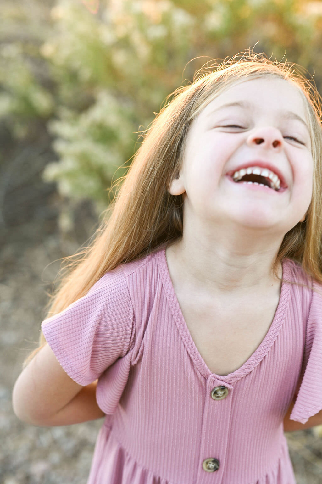 A child laughing while outside.