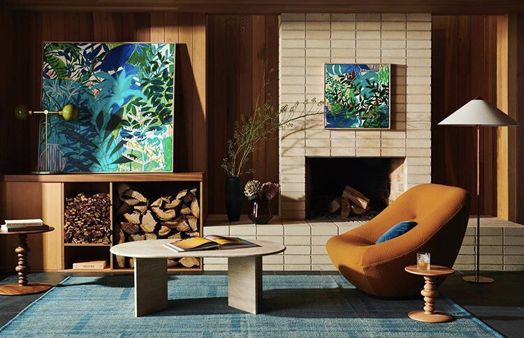 Earthy living room with brick fireplace, orange armchair and twin artworks, styled by residential interior designer in Melbourne.