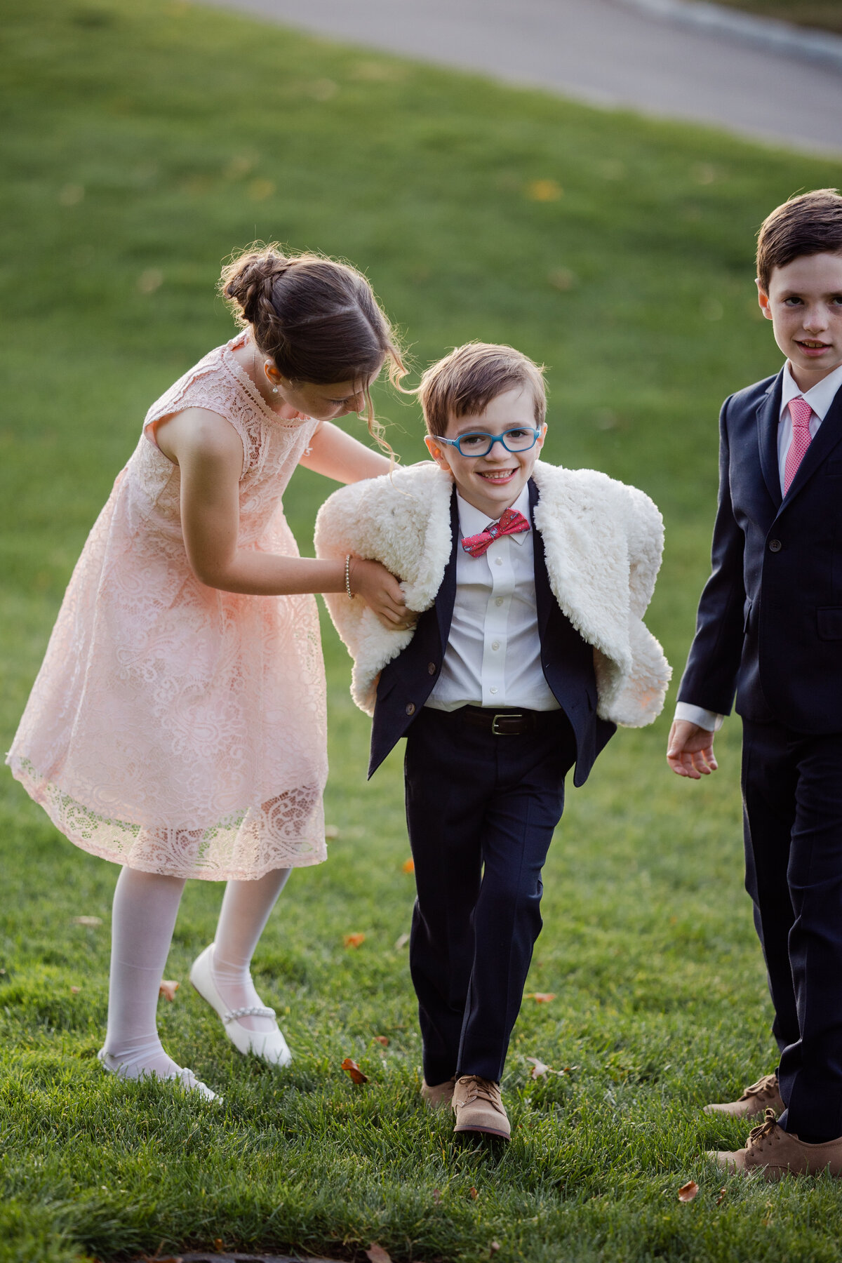 A Candid photograph of A child wearing a shawl at a wedding.