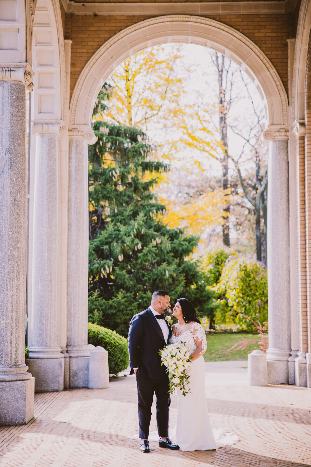 Indian christian malayali couple standing under the arches outside the immaculate conception roman catholic church in nj