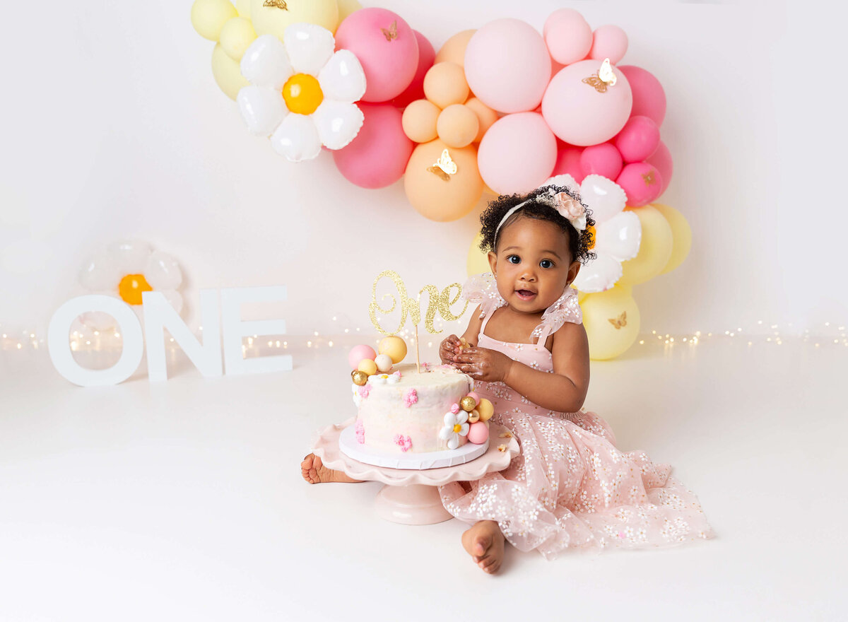 Cake smash pictures done for baby girl daisy theme pink yellow in Brooklyn studio by Rochel Konik Photography