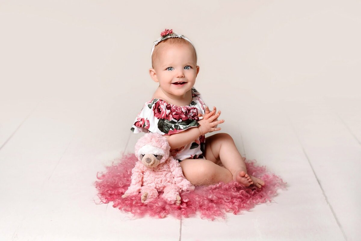 mobile-inhome-cakesmash-photography_vancouver-fraser-valley_1-year-girl-pink-floral-romper-sloth-toy