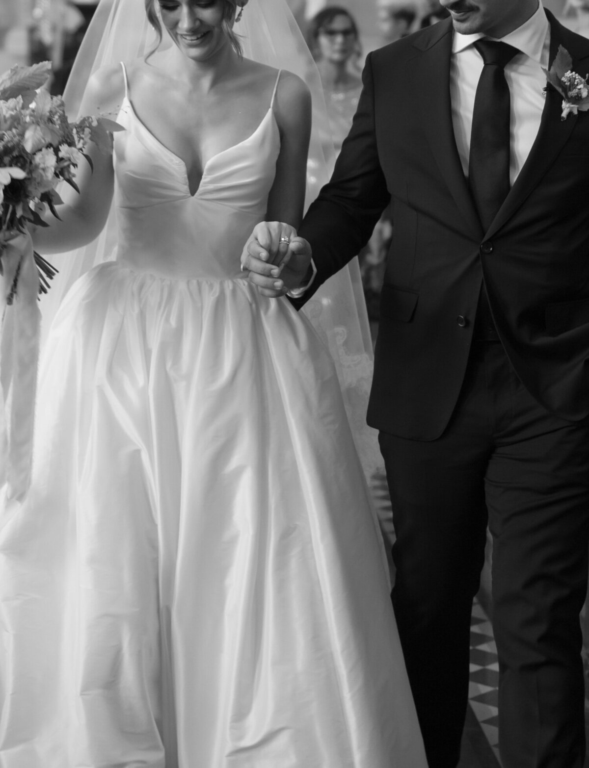 Detail of a couple holding hands with new wedding rings after their St. Peter and Paul church wedding ceremony