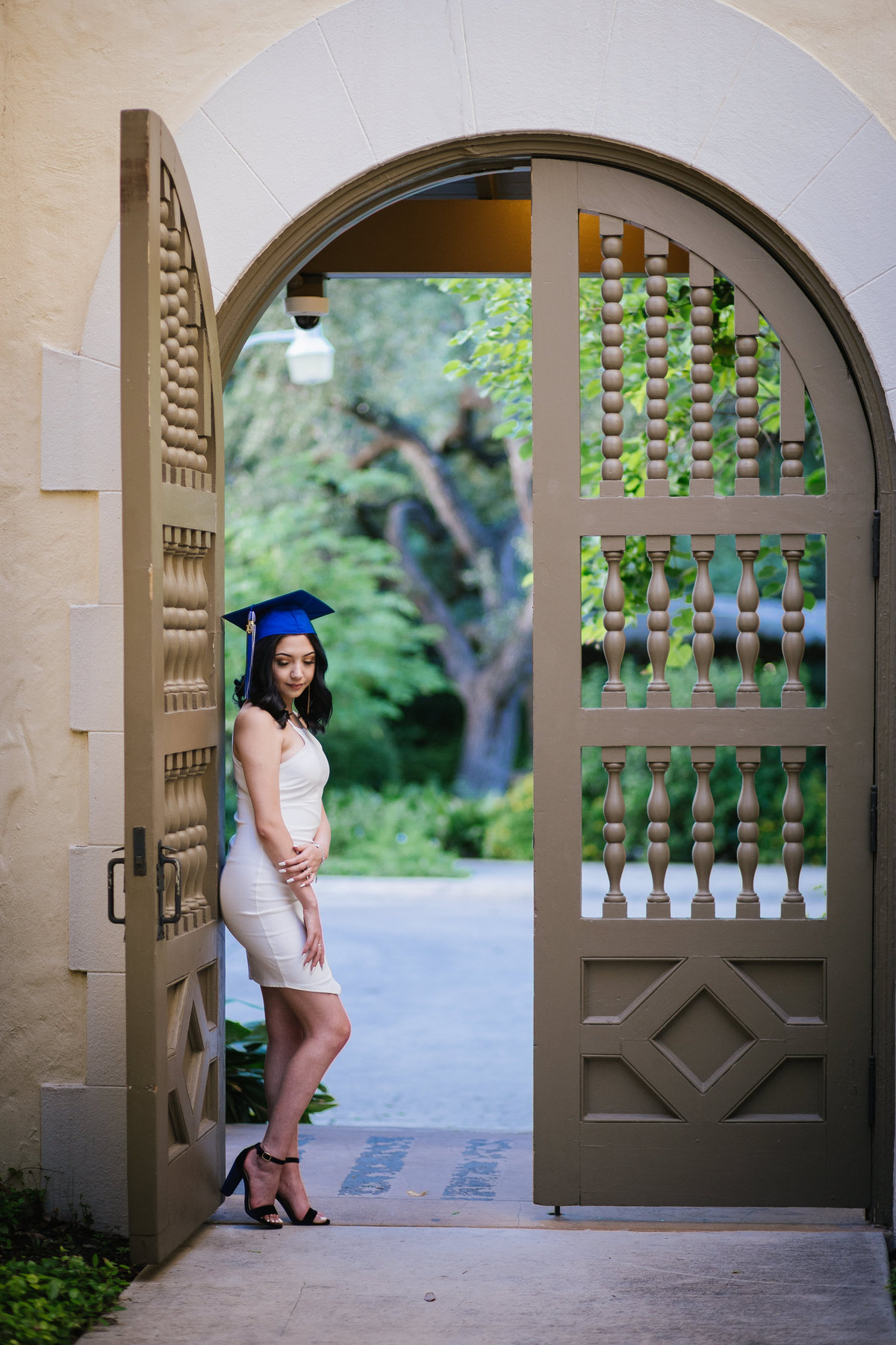high school senior girl standing in door archway by San Antonio senior photographer