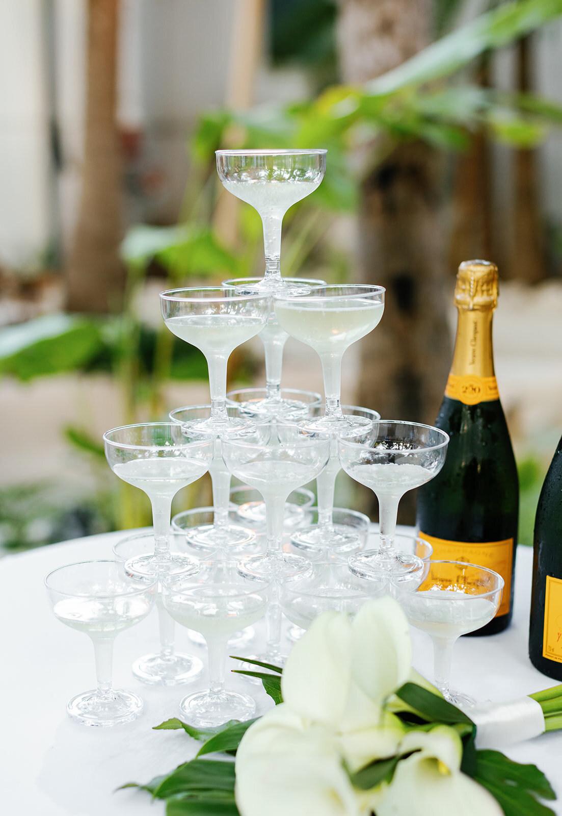 A luxurious champagne tower set against lush greenery, perfect for an elegant Florida Keys wedding reception.