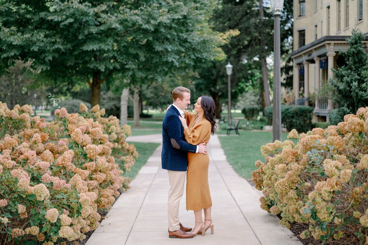 a couple embracing while standing on a college campus