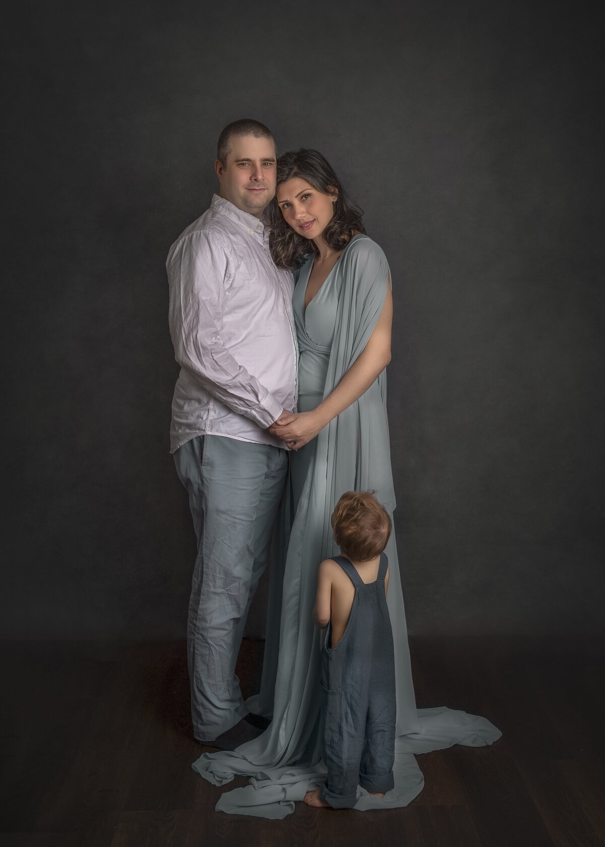Young son looking up at his parents during a heartfelt family studio session – Captured by Ottawa family photographer Sonia Gourlie