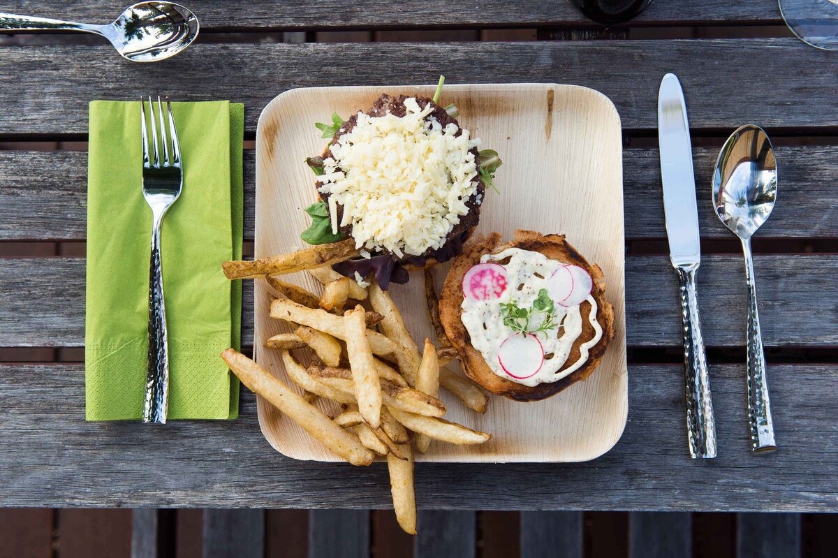 Burger with radishes and fries and dressed with cheese