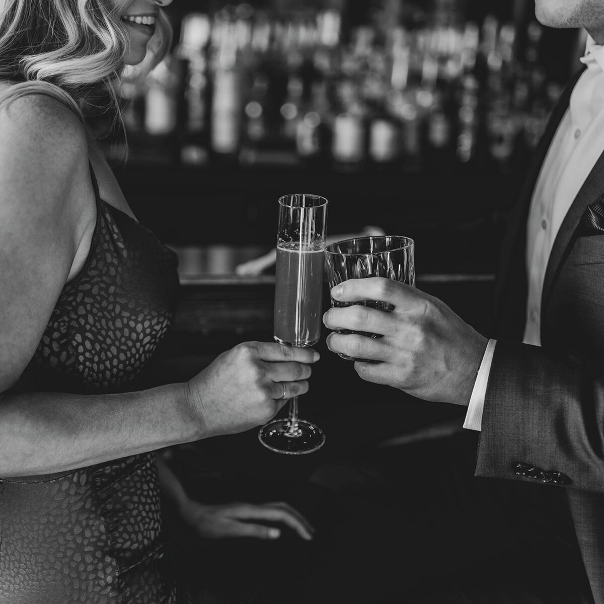 black-white-of-couple-clinking-glasses-at-bar