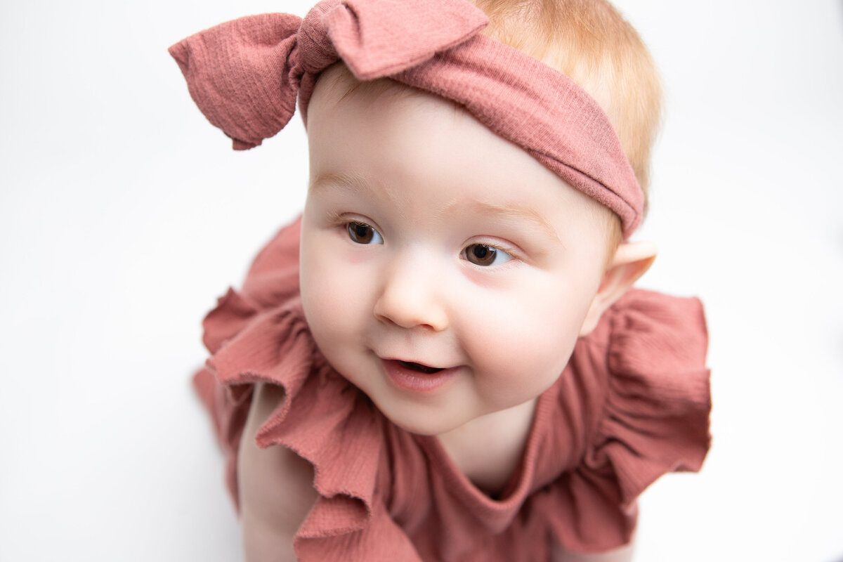 toddler girl in pink on a white backdrop