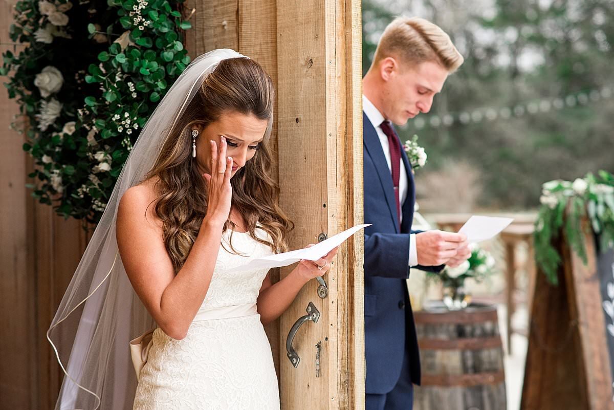 Bride and groom exchanging letters before first look, bride wiping away tears of joy
