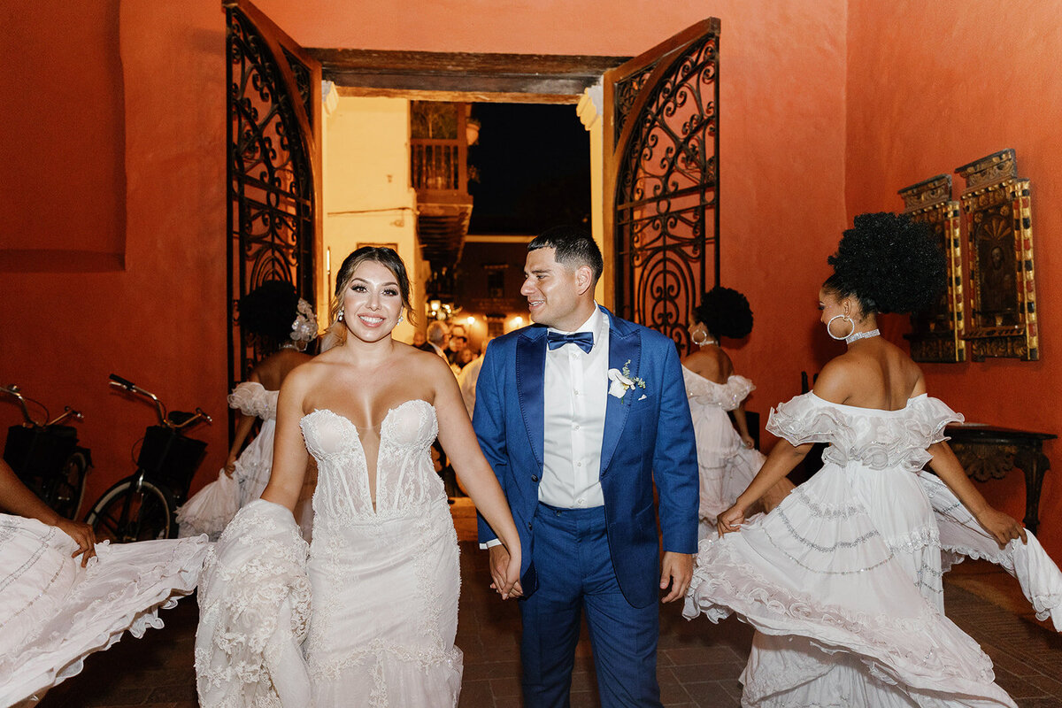 Victoria and Daniel make a grand entrance at their Cartagena Colombia wedding reception, surrounded by traditional Colombian dancers.