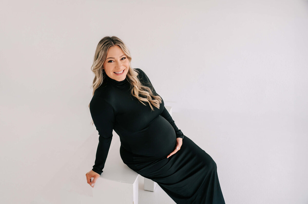 maternity picture in Joplin MO of pregnant mom sitting on white step smiling