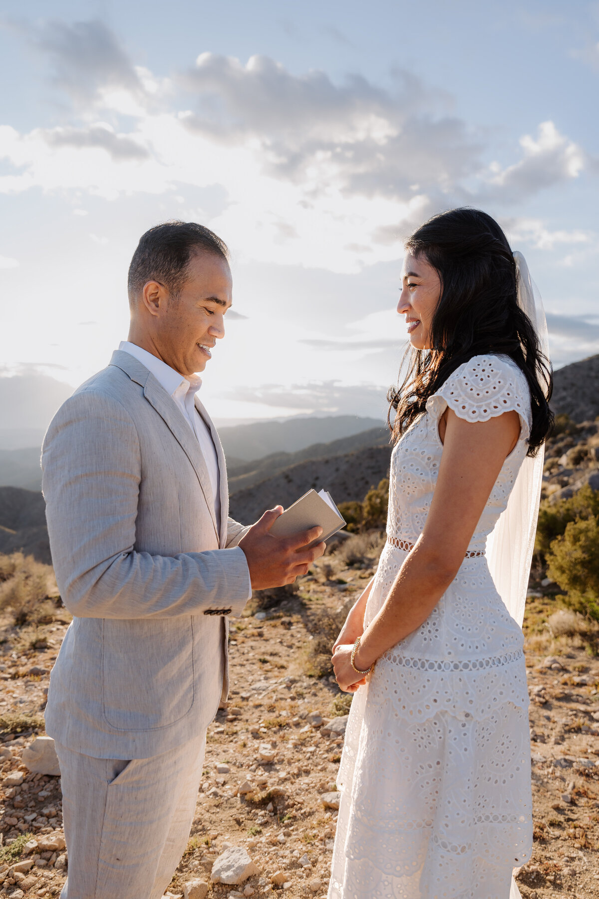 Joshua Tree elopement with bride and groom at Keys View reading vows during sunset.