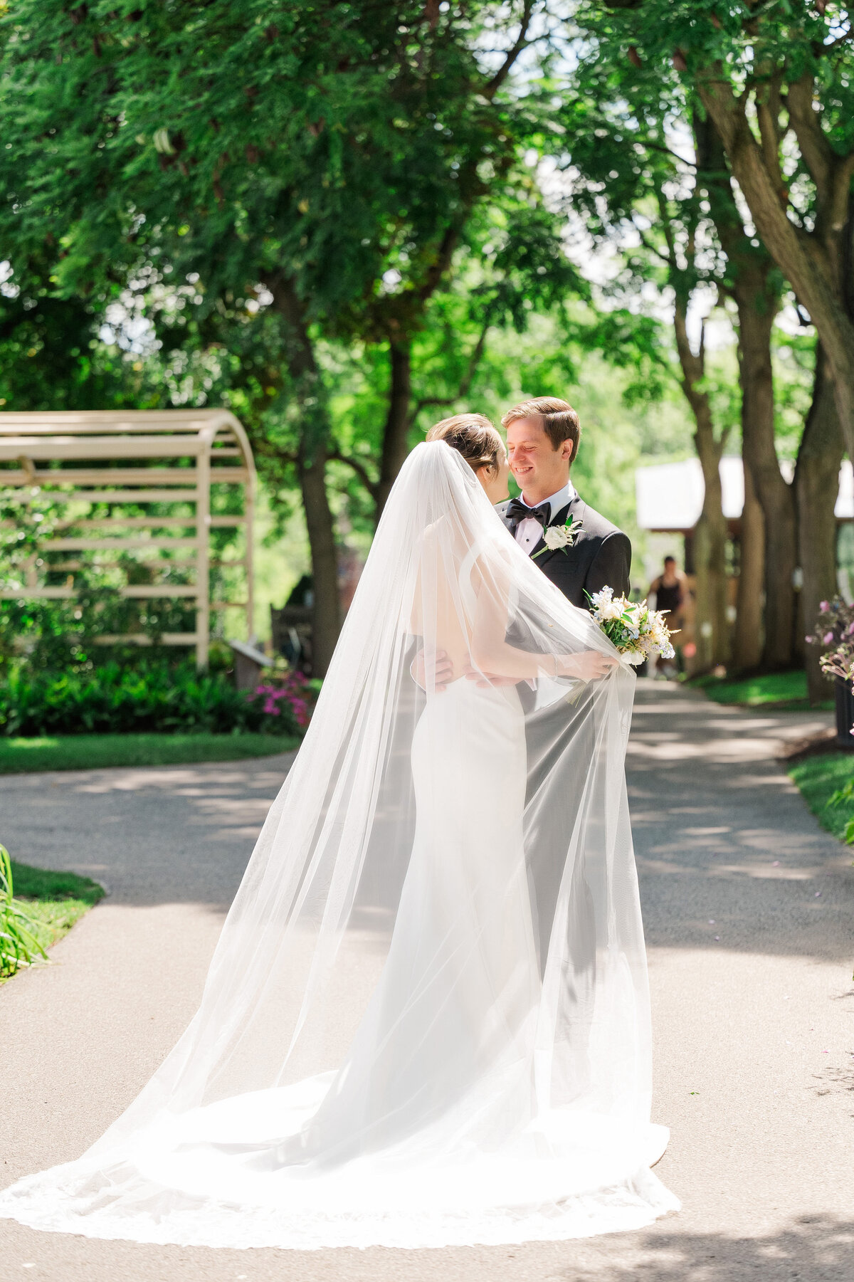 bride and groom looking at each other on wedding day with the sunlight shining in a cathedral veil