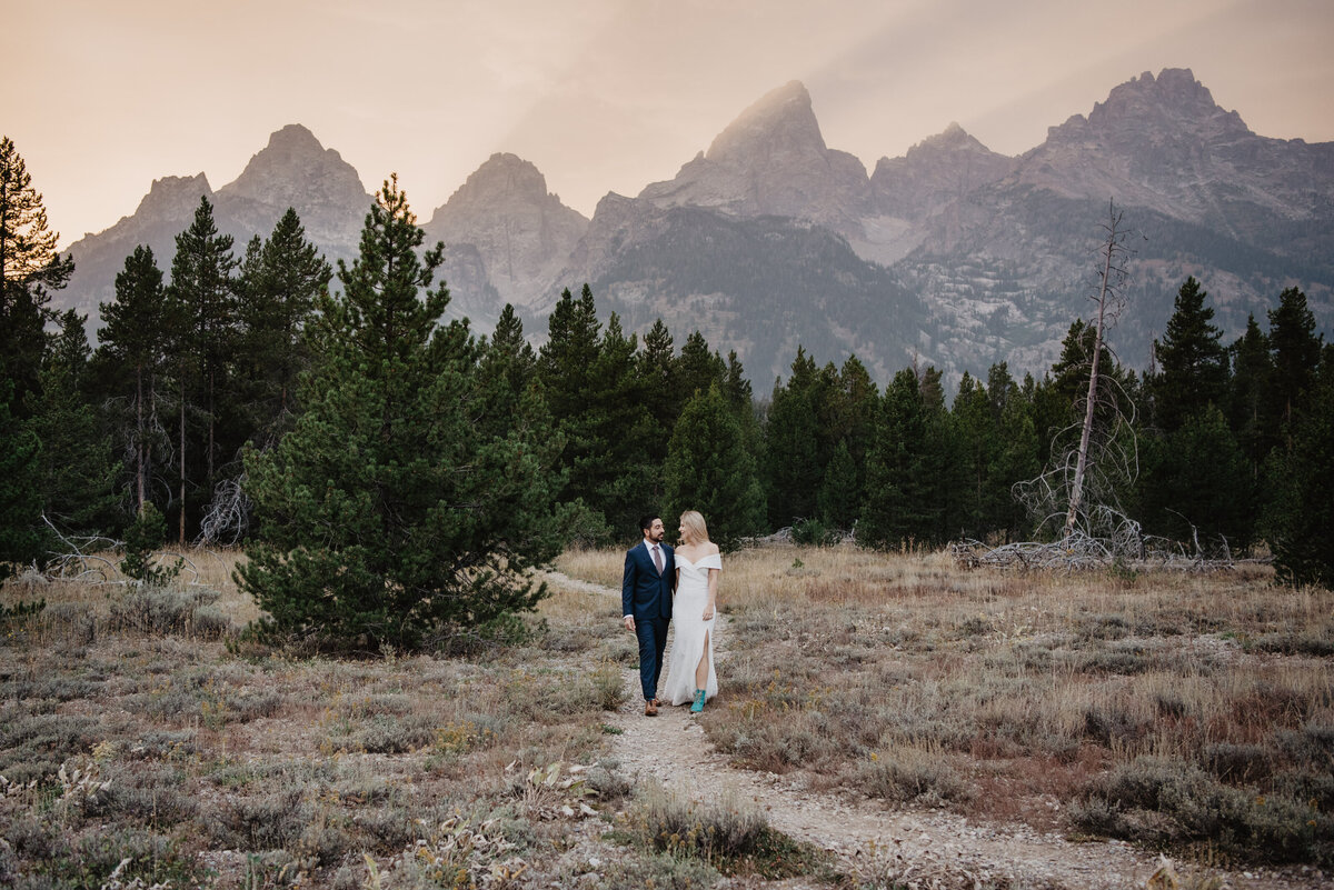 Photographers Jackson Hole capture bride and groom walking into park