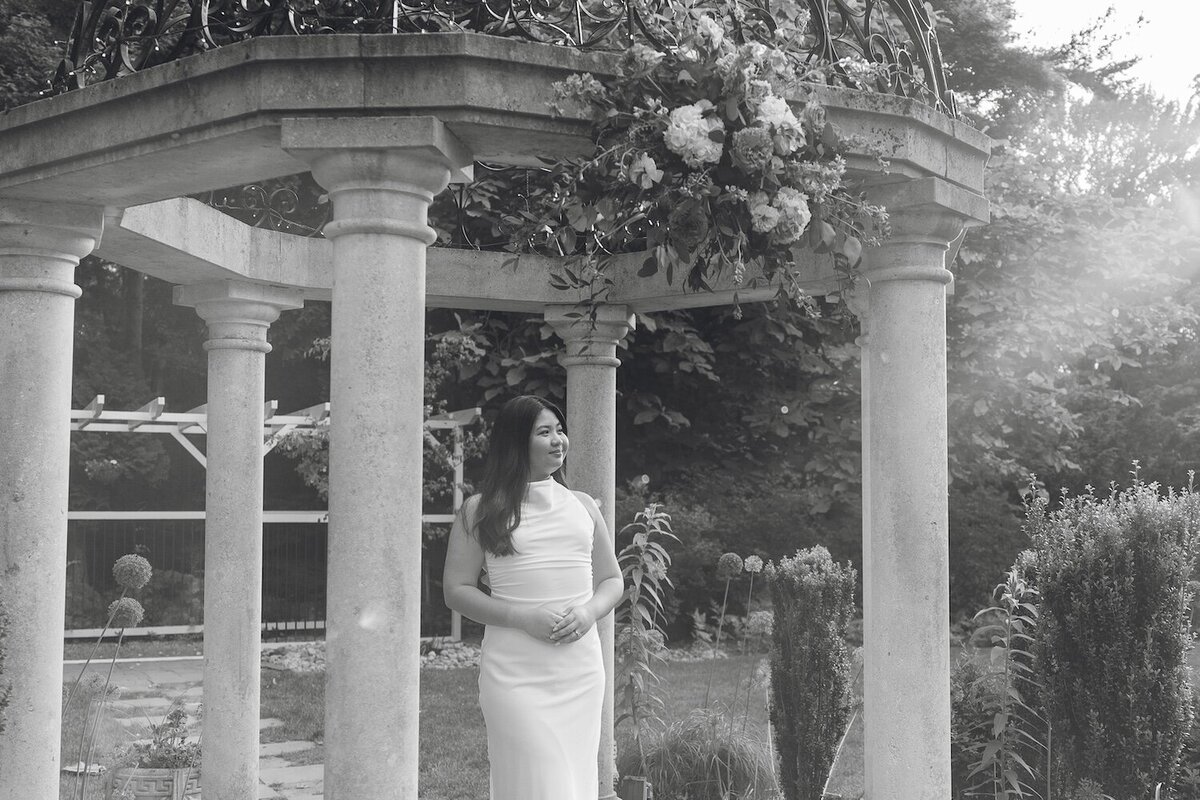 Black-and-white image of bride-to-be under the pergola at Sayen Gardens.