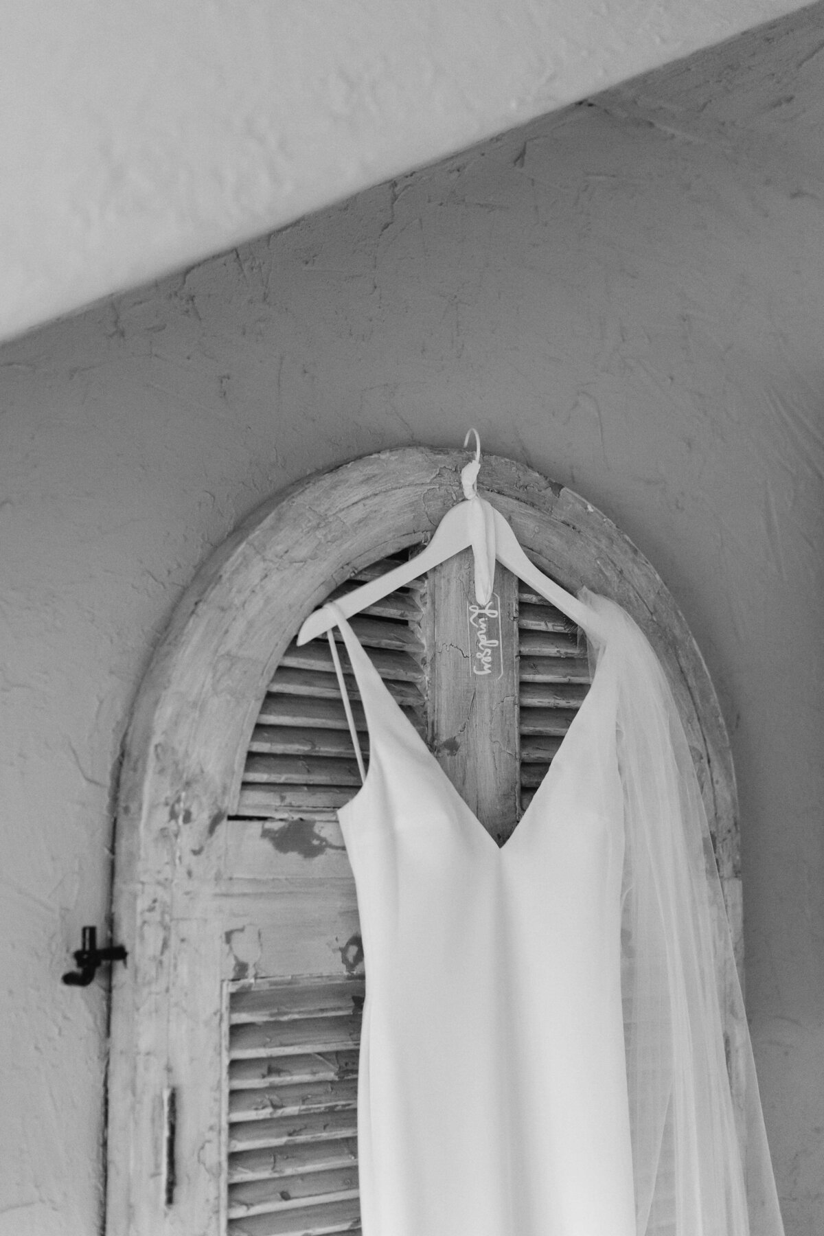 Black and white wedding dress hanging on vintage door at chateau selah