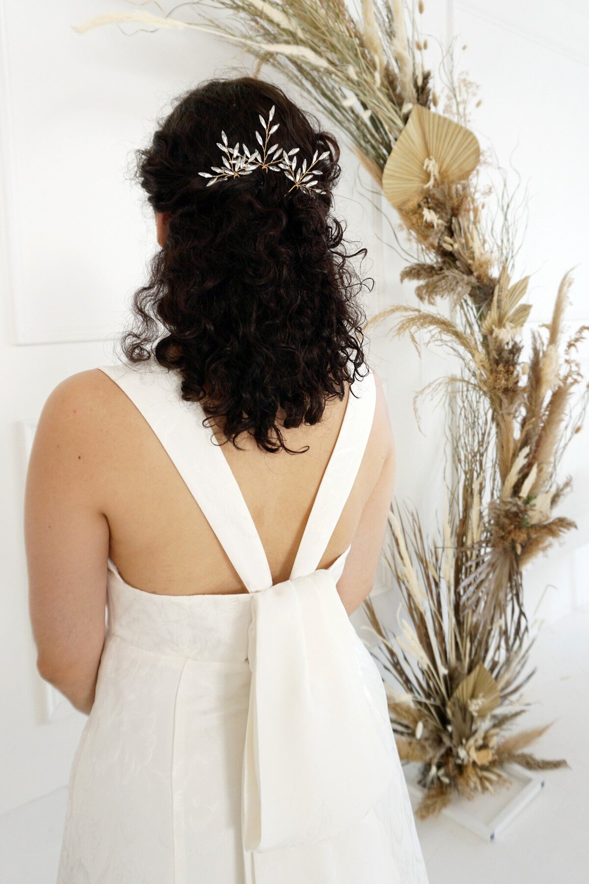 Detail shot of the detachable oversized bow and the v-back of the Sol wedding dress style.