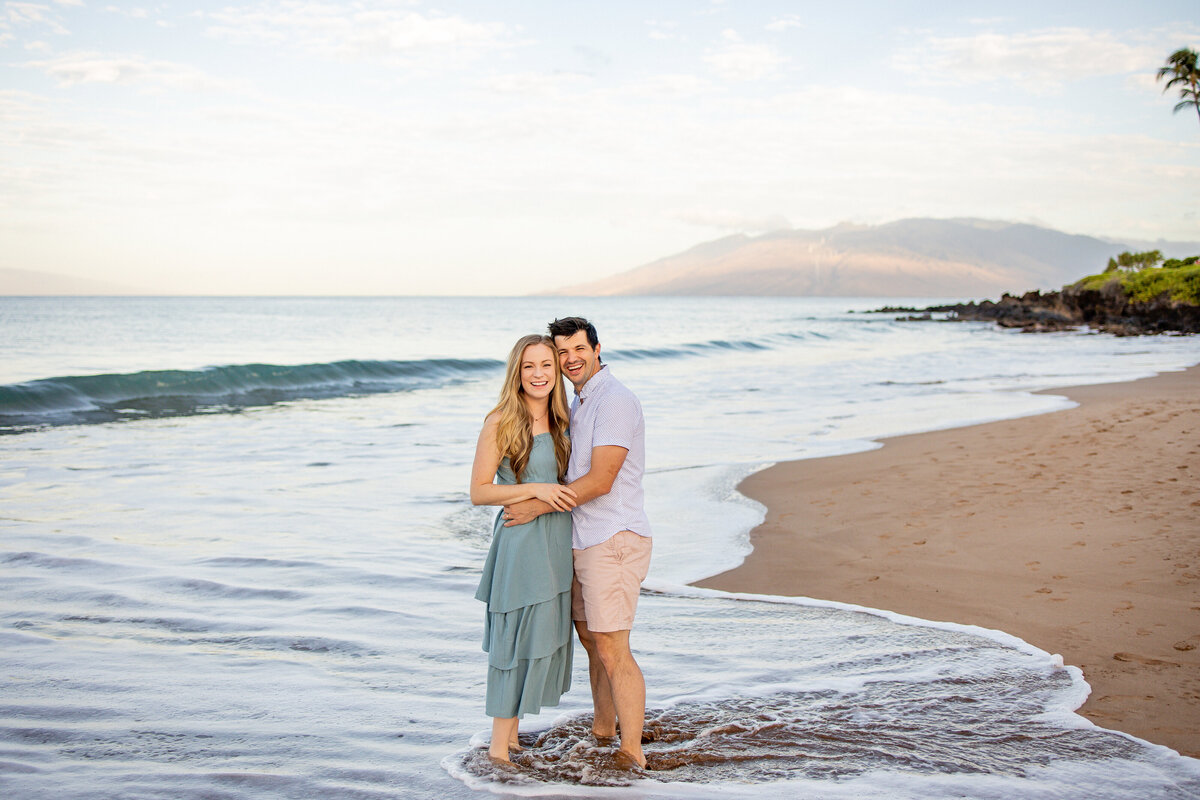 Maui Family Photographer captures couple touching cheeks while embracing in water