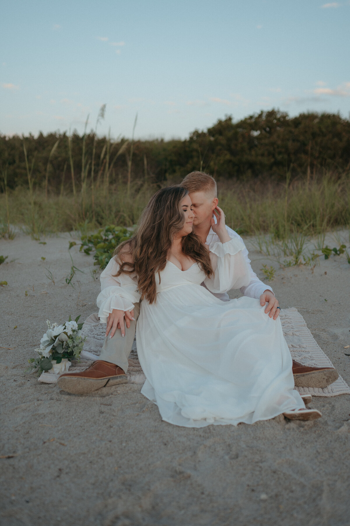 couple sitting in sand during elopement in florida