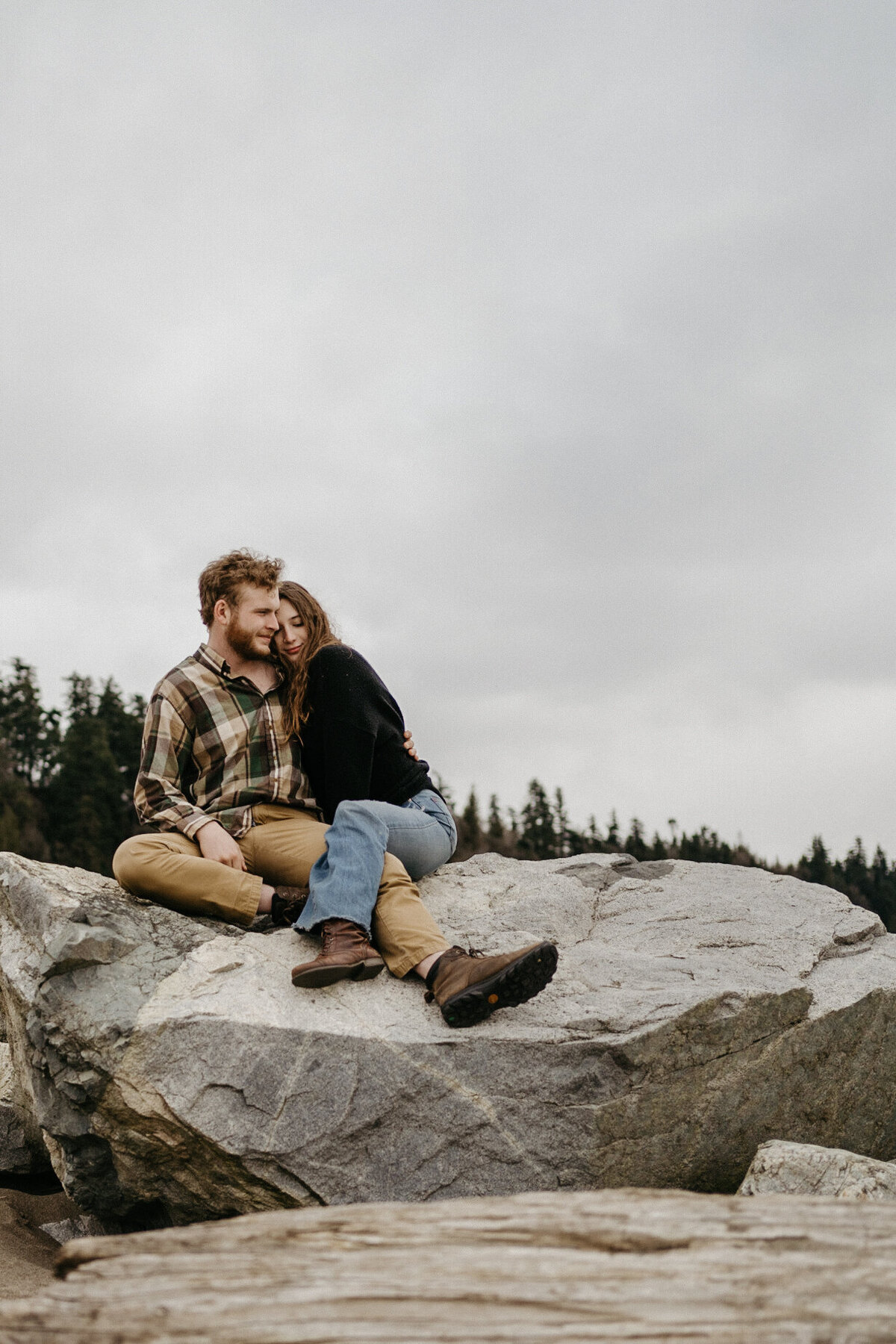 couple sitting on rock embracing