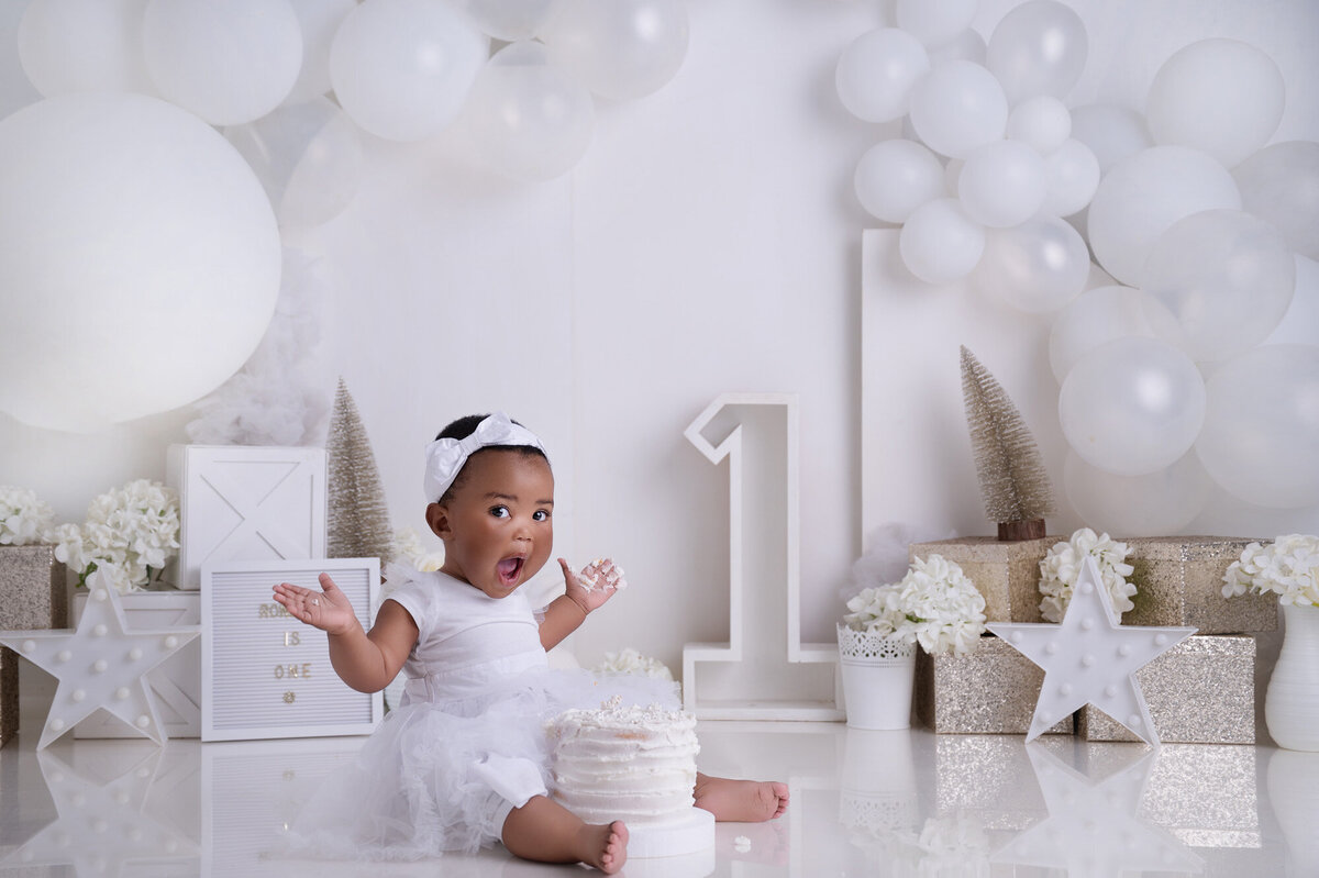 white and gold cake smash setup flowers and glitter