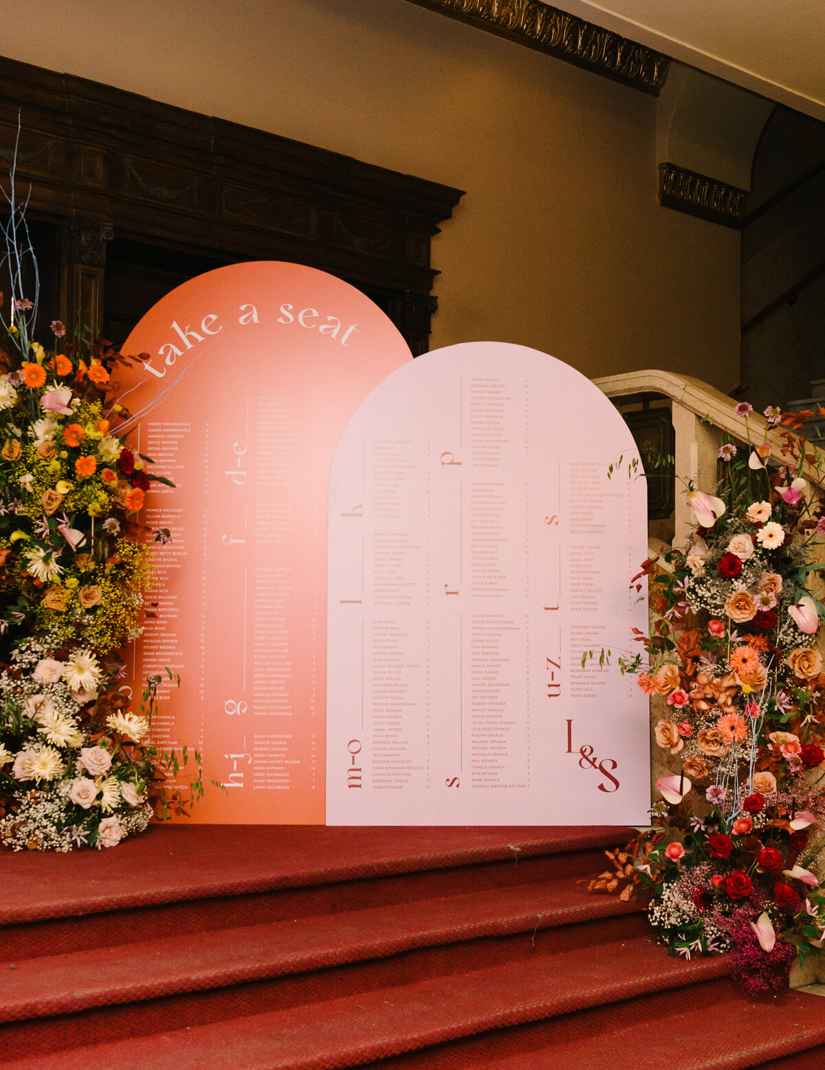A place card display on the steps of the Rialto theatre decorated with pillars of bright flowers.