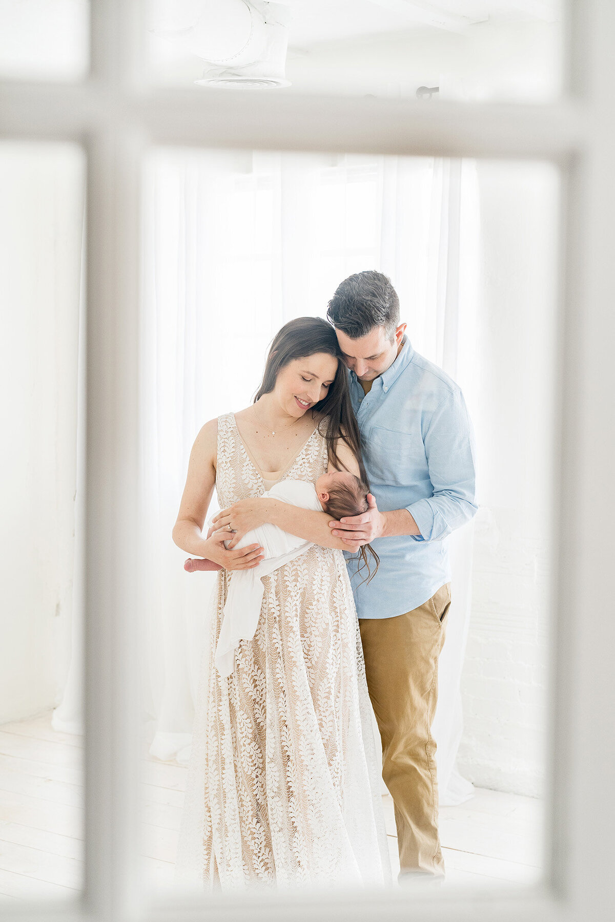 Louisville KY couple stand holding their newborn baby at Julie Brock Photography Studios in Kentucky