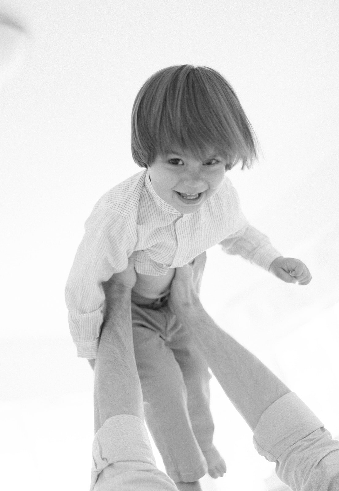 A black and white portrait of a young child joyfully playing, taken during a Florida Keys family session. Claudia Amalia Portrait Photography.