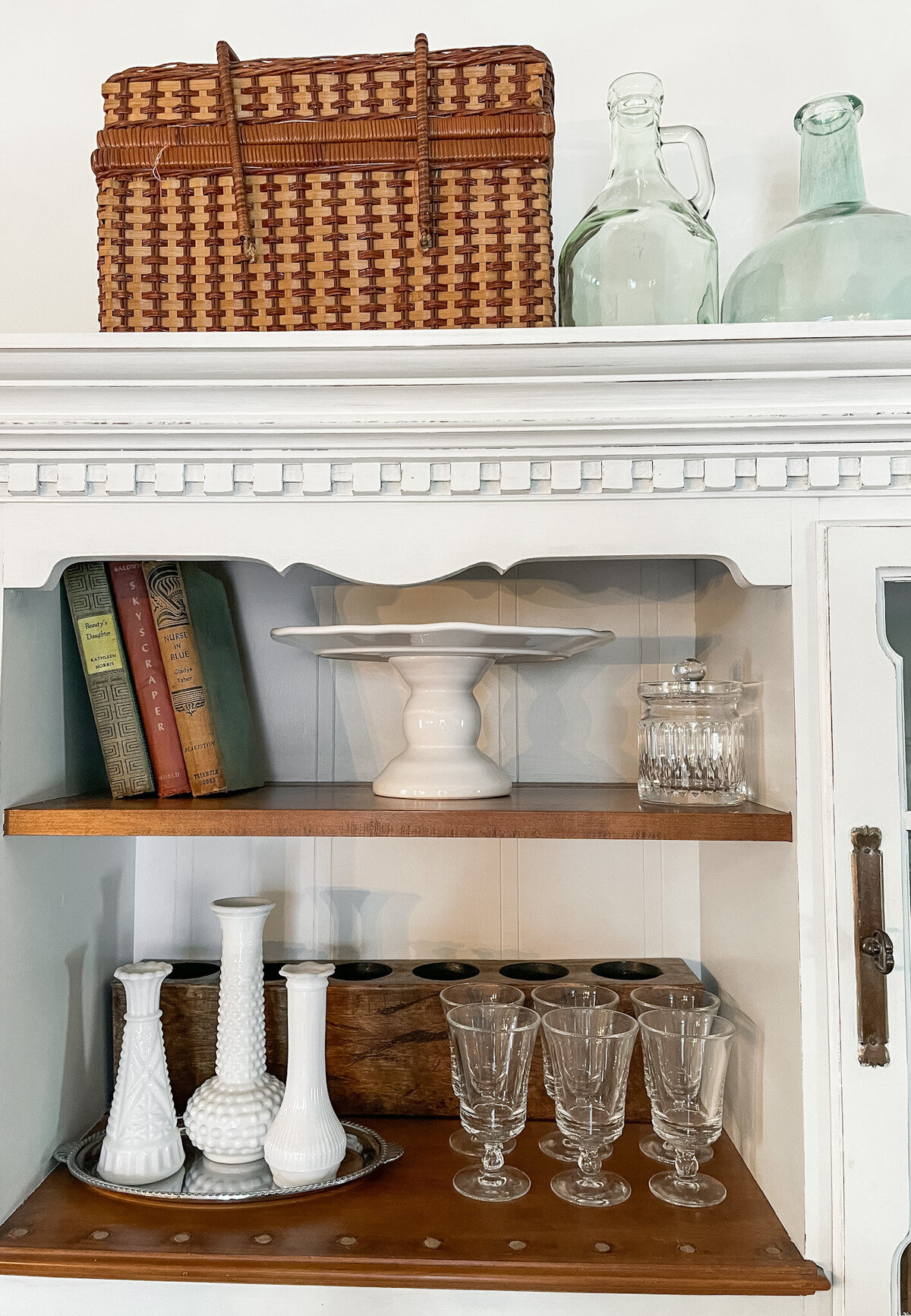 Antique hutch with antique vases , books and glassware