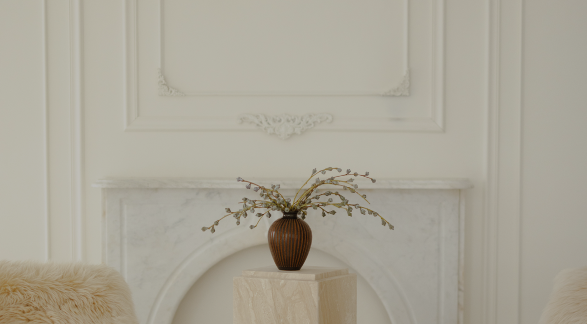 Flowers flowing out of a vase in front of a white wall with ornate molding in a photo studio rental space.