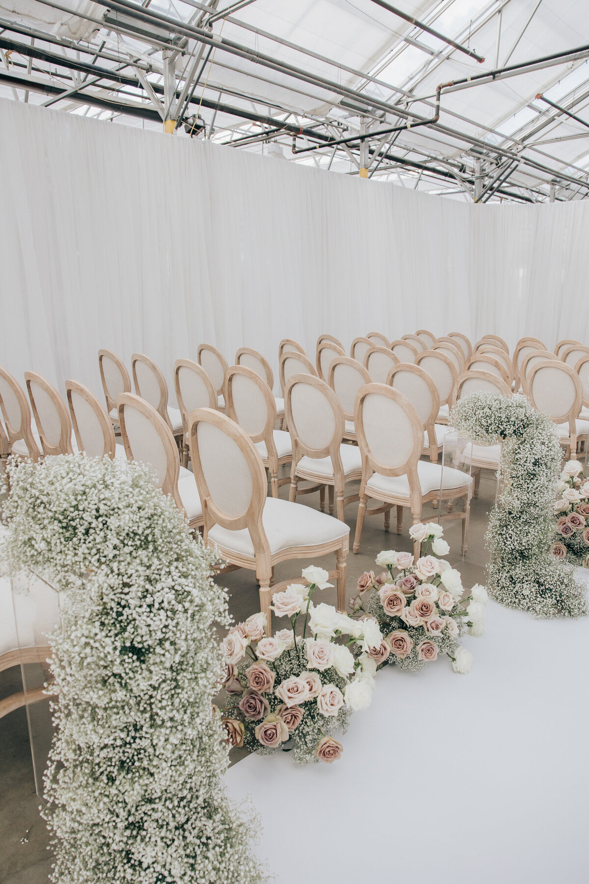 Baby's breath and roses line the aisle of luxury RL Designs wedding photographed by Nova Markina