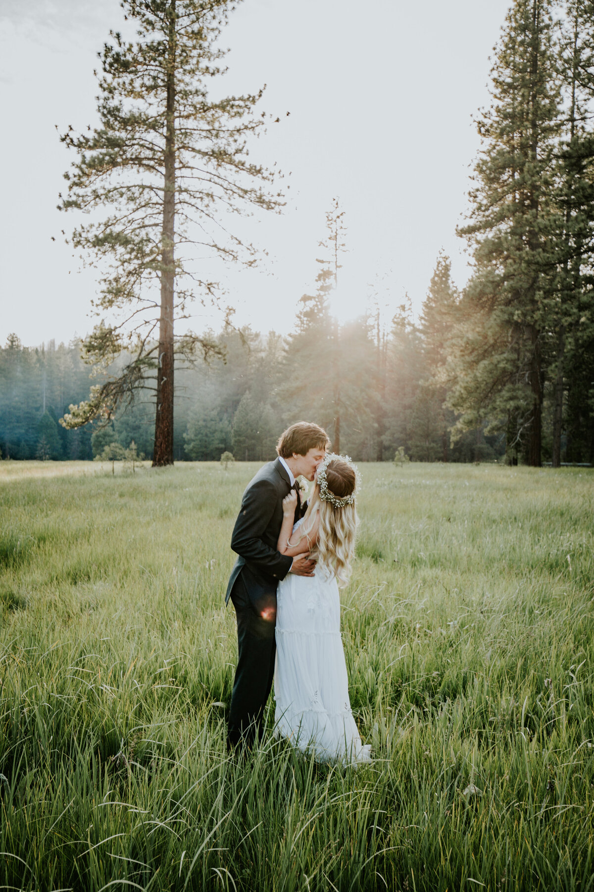 Bride and groom  kiss in the middle of forest meadow.