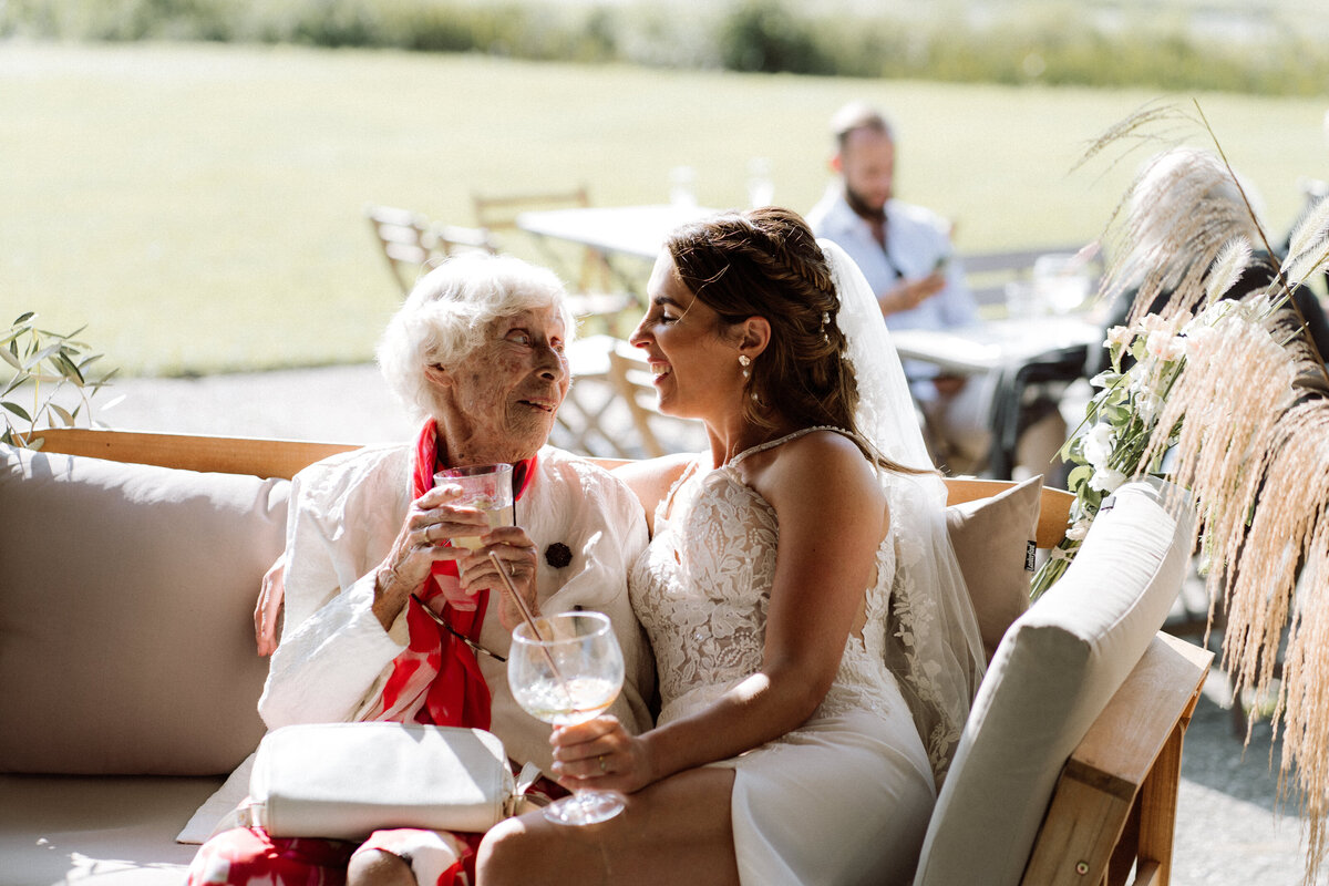Sfeervolle bruiloft bij Nigtevecht Freeland Farm, met een persoonlijk aangekleed decor en het bruidspaar dat geniet van een lange borrel in een gezellige, intieme sfeer. Intiem momentje met oma en de bruid. 