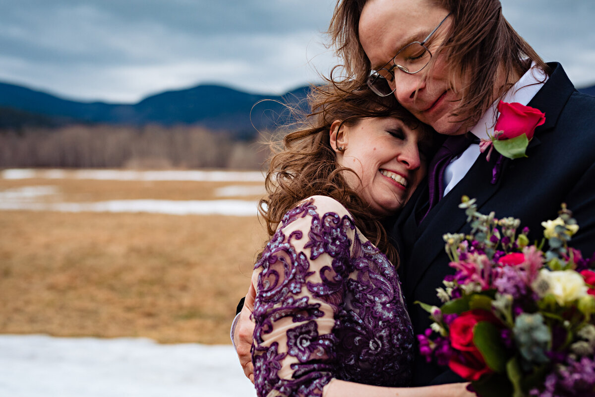 White Mountain elopement in Jackson NH with the cold couple embracing in the winter weather