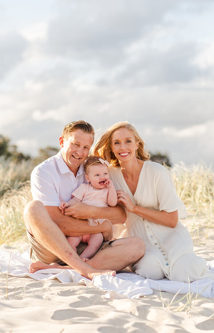 Family photo on a Shorncliffe beach: Candid lifestyle shot with mum holding baby