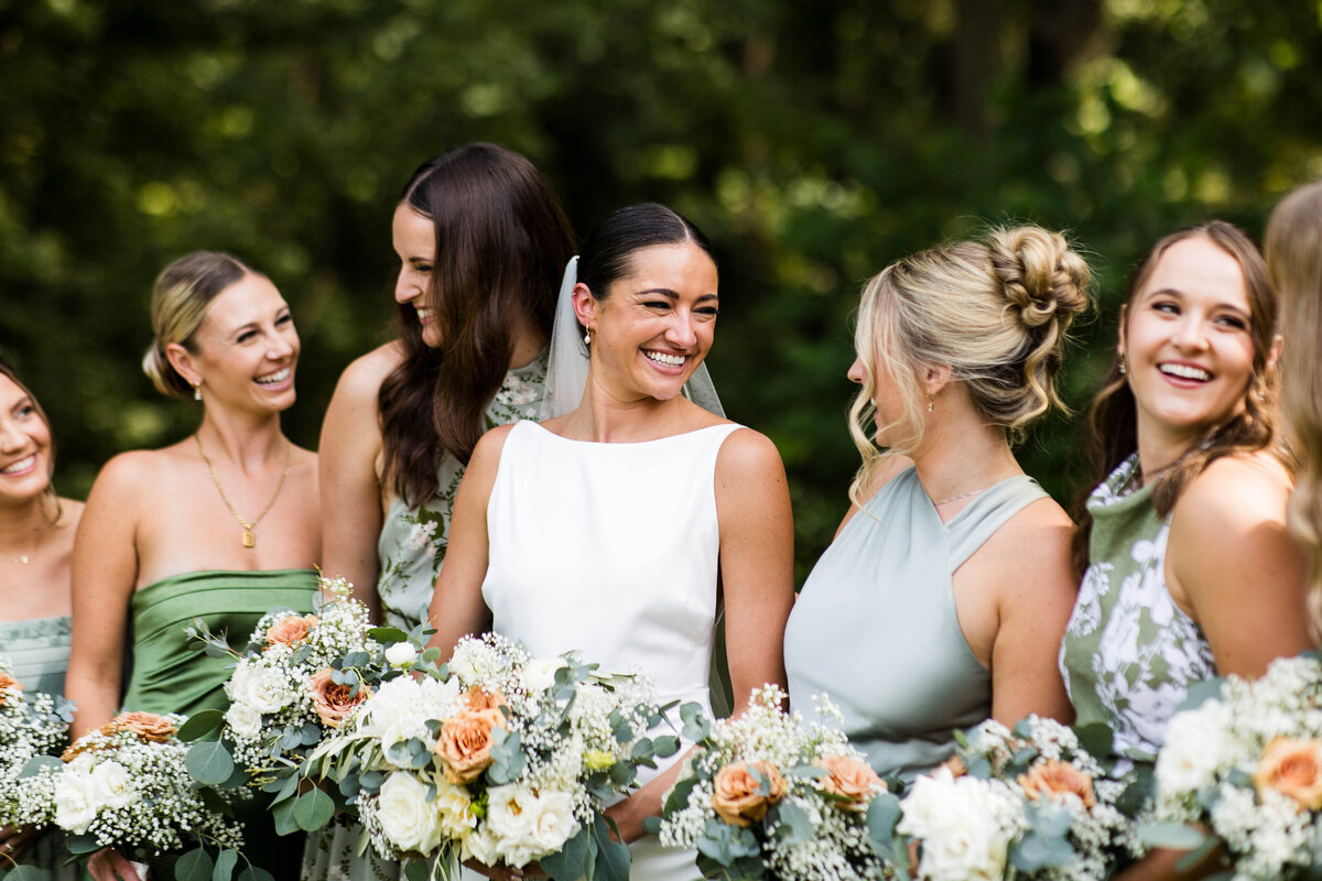 Bridal party smiling with soft glam makeup and elegant hairstyles in Madison, WI.