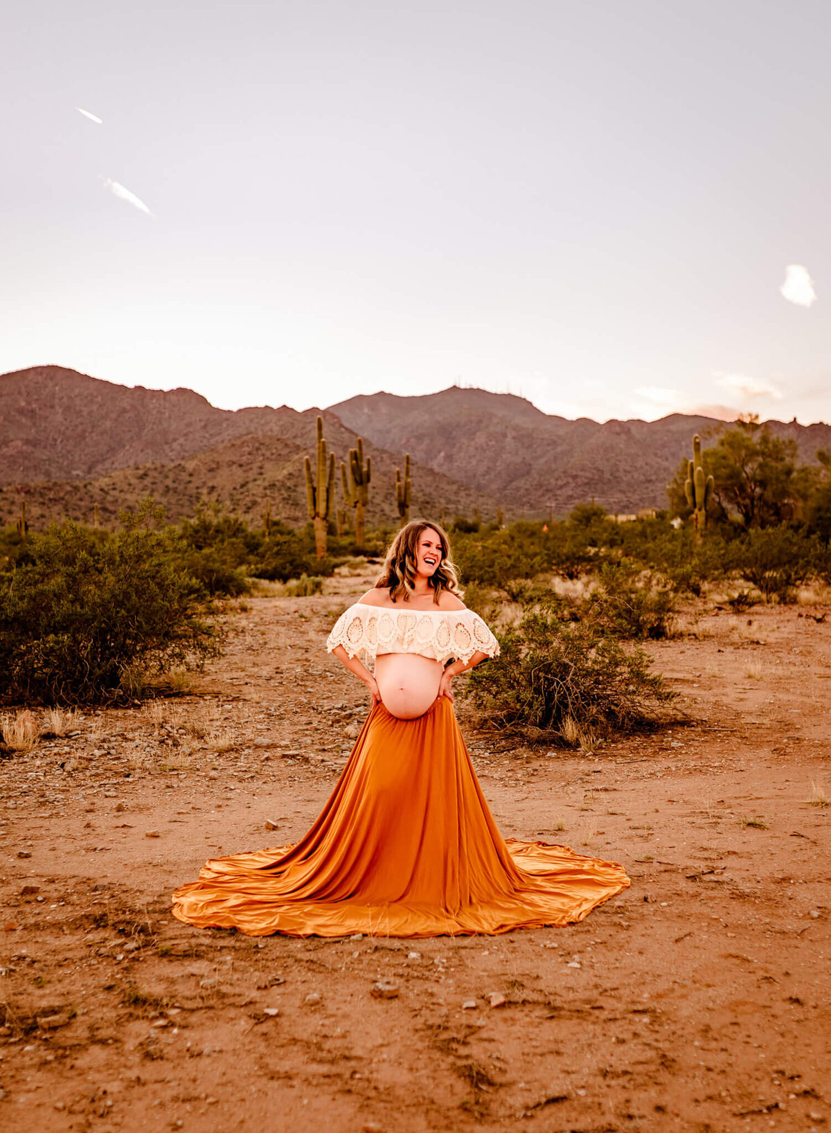 mom-to-be wearing boho gown showing belly in AZ desert photoshoot