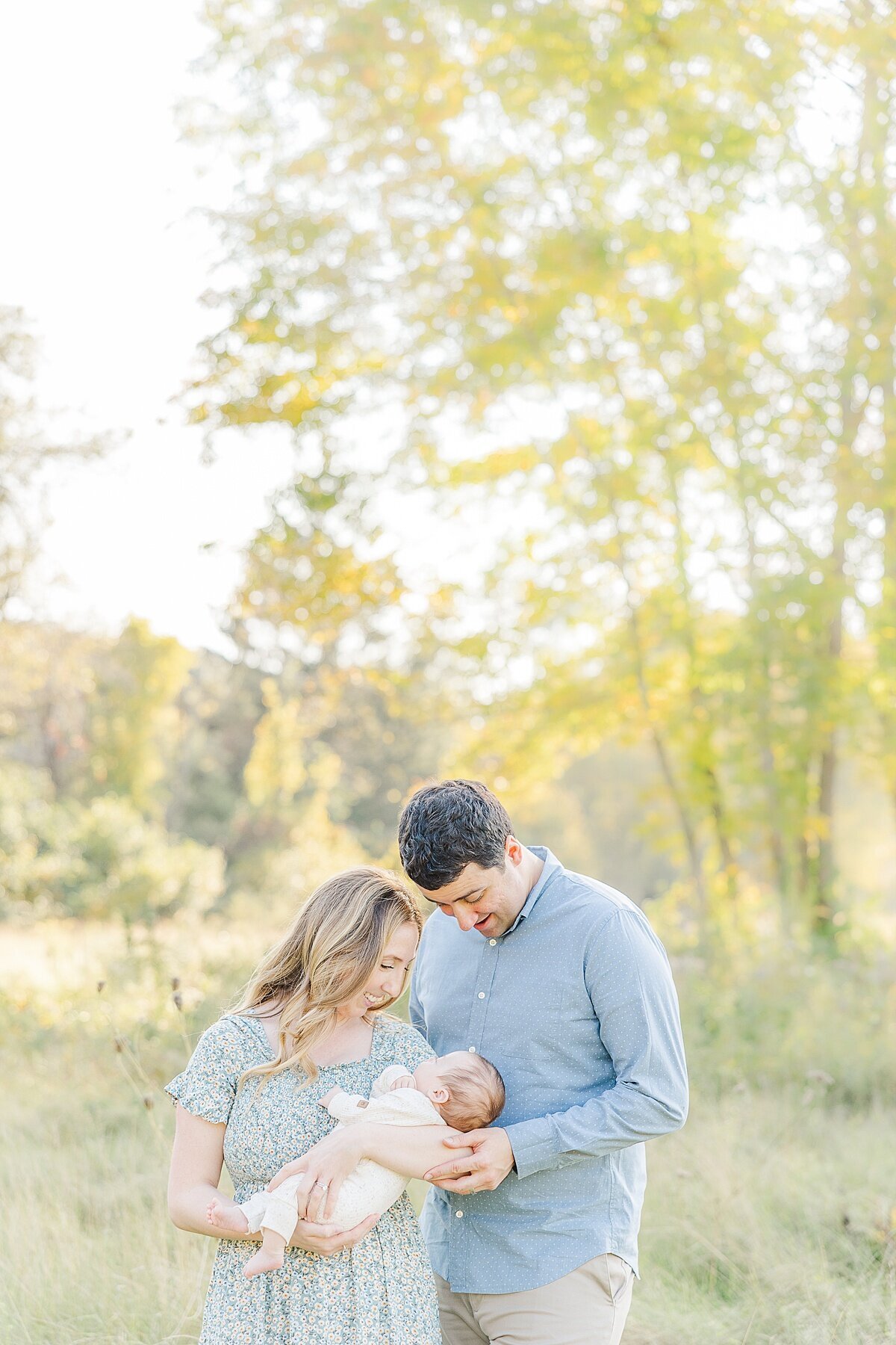 parents hold baby during outdoor newborn photo session in Natick Massachusetts with Sara Sniderman Photography