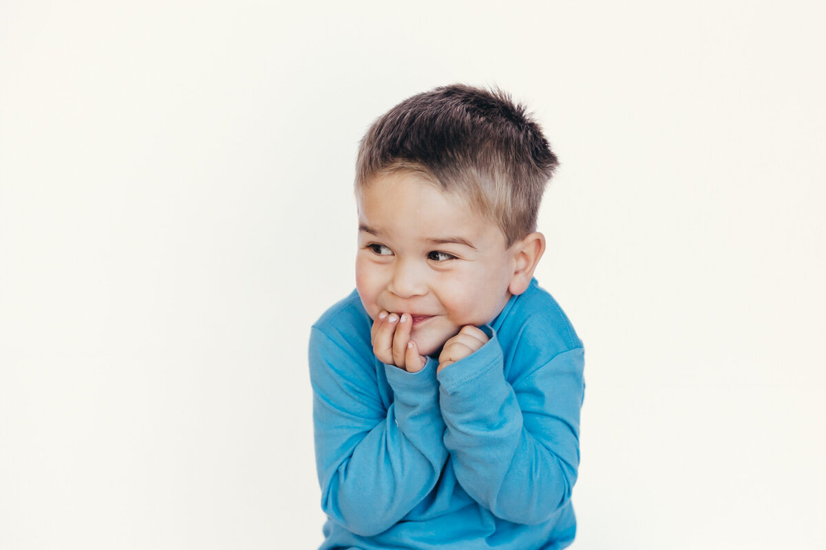 A young boy gives a playful expression during his portrait with personality session with Christine Dammann