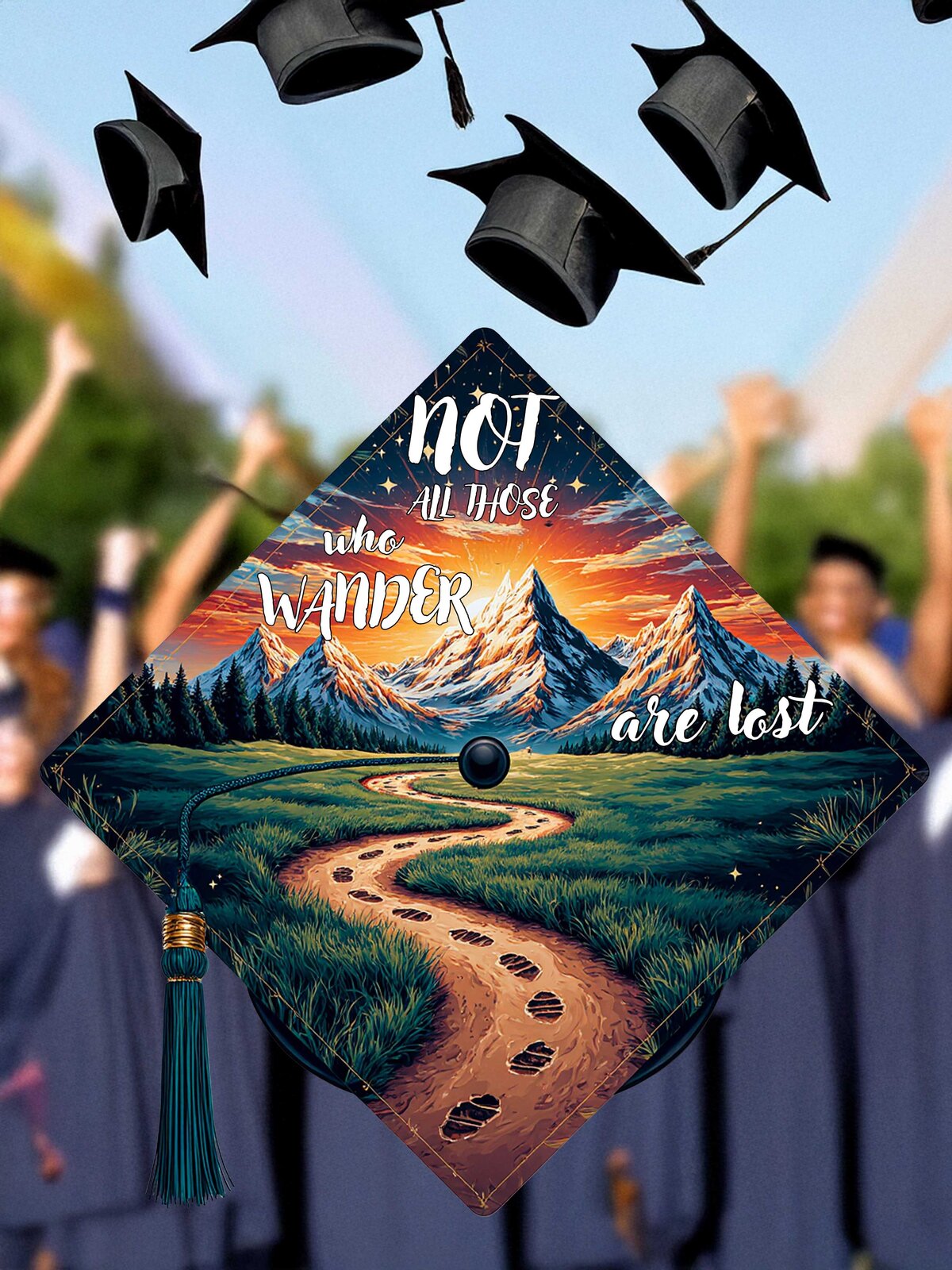 A branded photography shot of custom painted graduation cap with a winding path leading to Mount Tassel and the quote "Not All Who Wander Are Lost" quote 