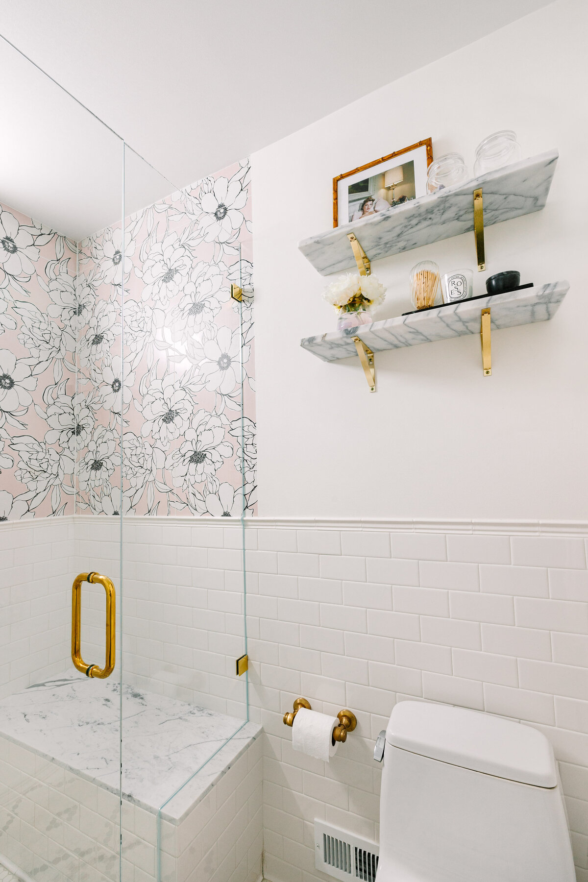 Small space bathroom with Walker Zanger floral porcelain tile shower, frameless shower glass, and black and white Restoration Tile floor.