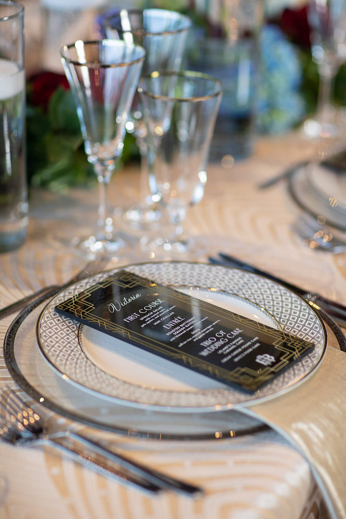 Silver and gold charger and china tablescape with acrylic menu card.