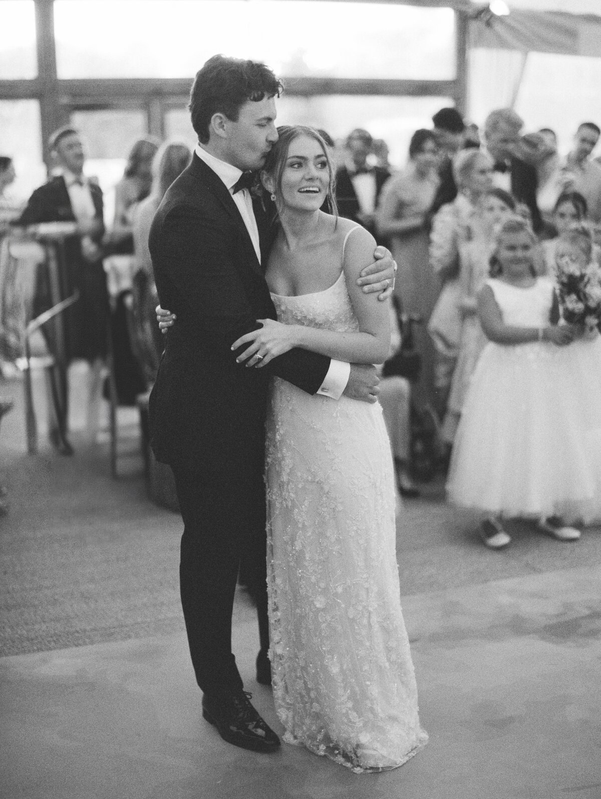Groom embraces his stunning bride as she smiles on their wedding day