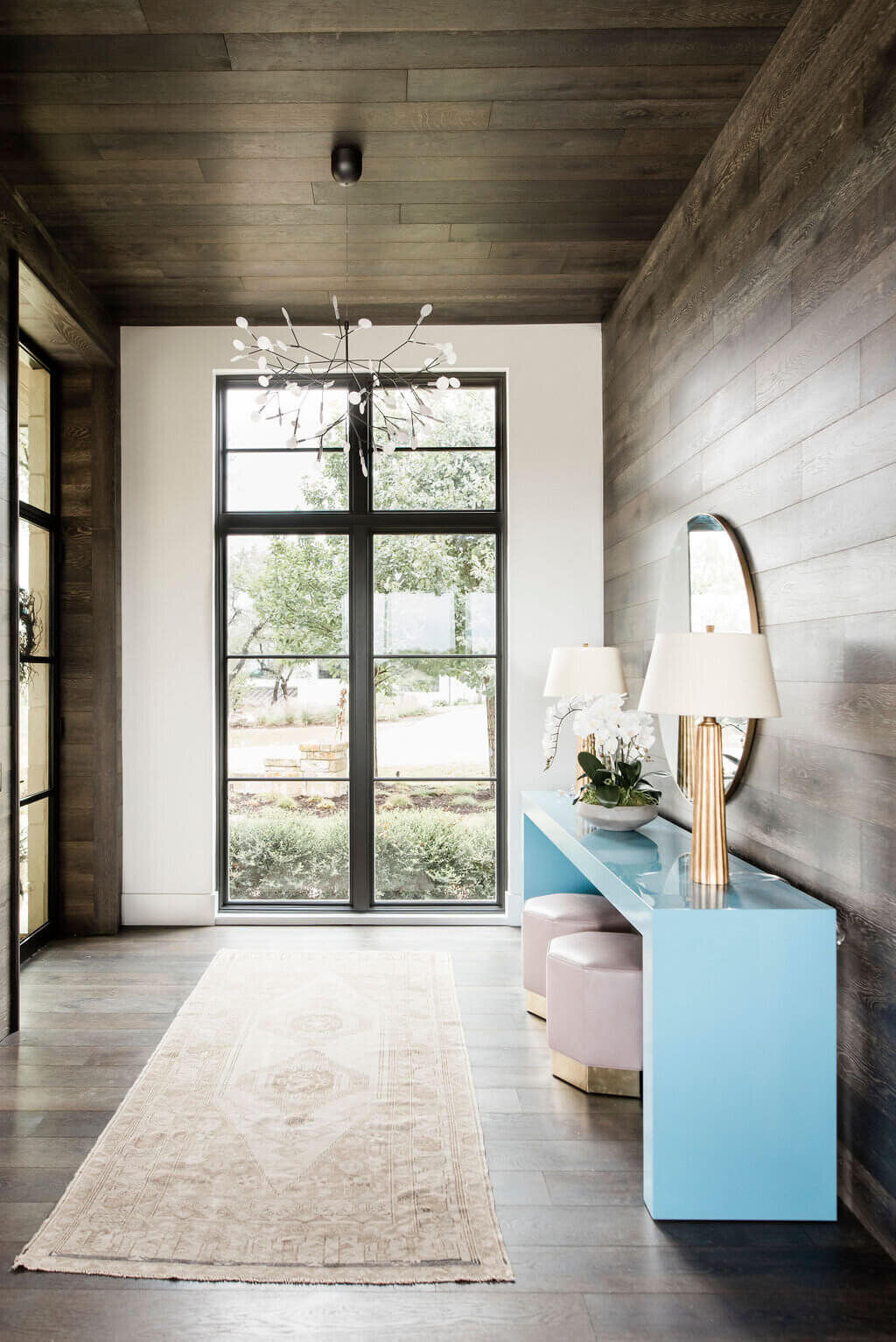oyster creek studios austin barton creek blue side table with pink stools and mirror in entryway