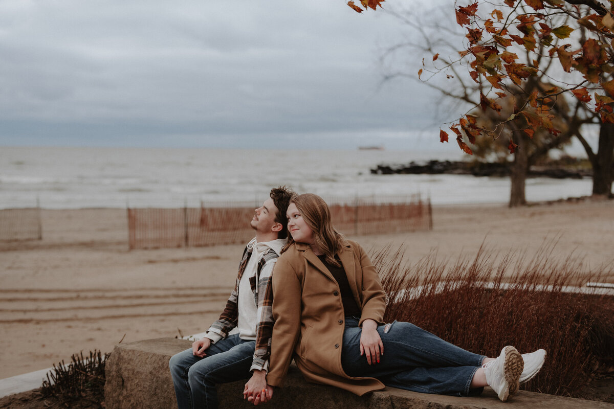 A couple enjoys a peaceful moment together at Edgewater Park in Cleveland, Ohio, with the stunning Lake Erie view in the background. Captured during golden hour, this portrait session showcases the couple's natural connection in one of Cleveland's most scenic waterfront locations. Perfect for couples looking for a relaxed, outdoor photoshoot.