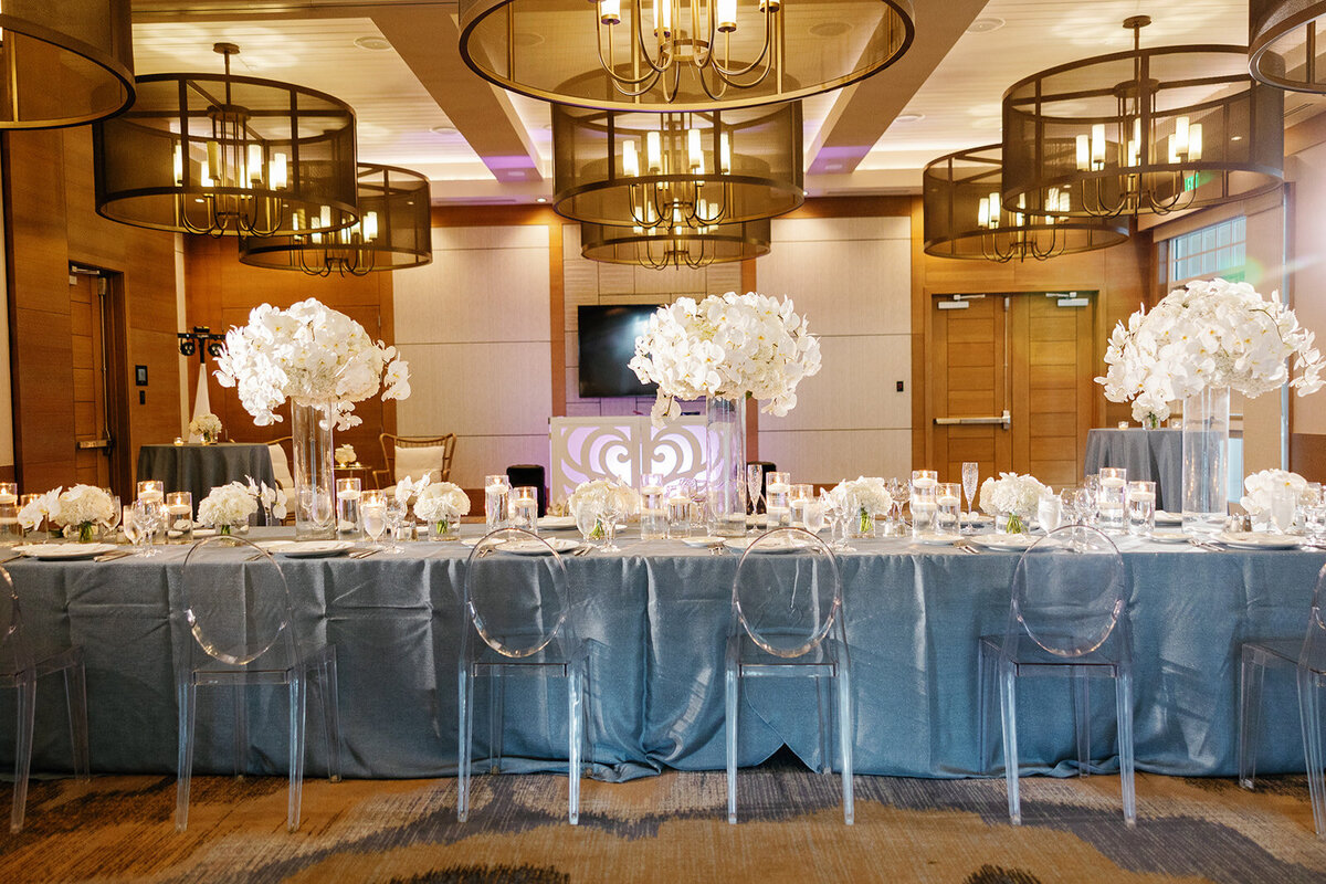 A beautifully styled wedding reception table with white floral arrangements and candlelight at Ashley and Cameron's micro wedding at Ocean Reef in Key Largo, captured by Claudia Amalia Photography.