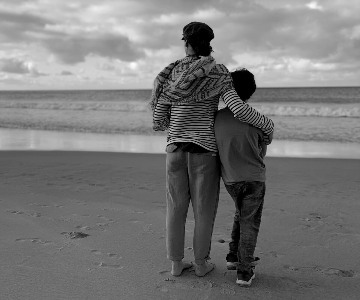 garielle founder of fifty7kind on beach with son